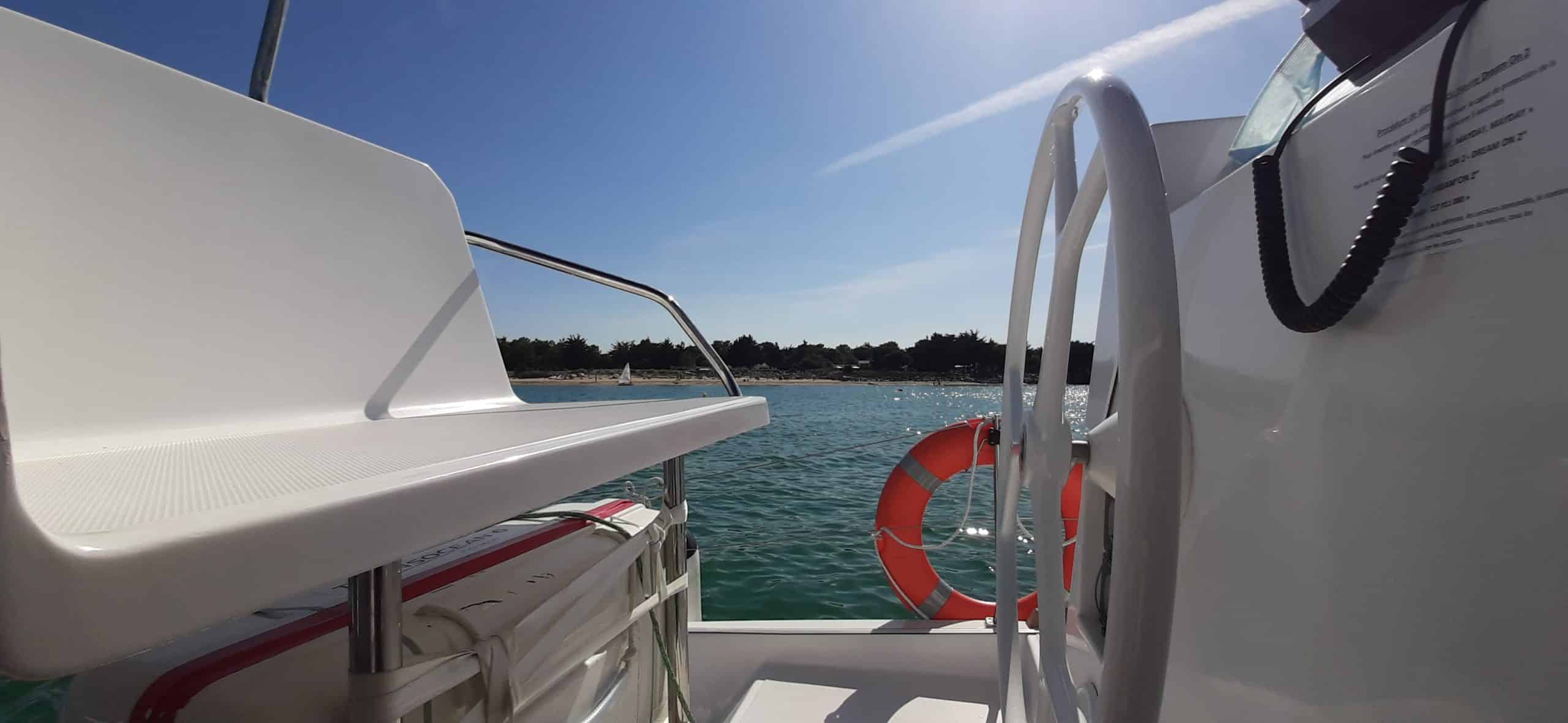 Bateau Catamaran sur l'eau, ciel bleu.